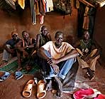 Simon Juma and friends sitting on the floor of his tent in thesudan kakuma camp