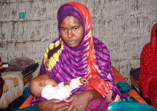 woman holding her sleeping malnourished baby